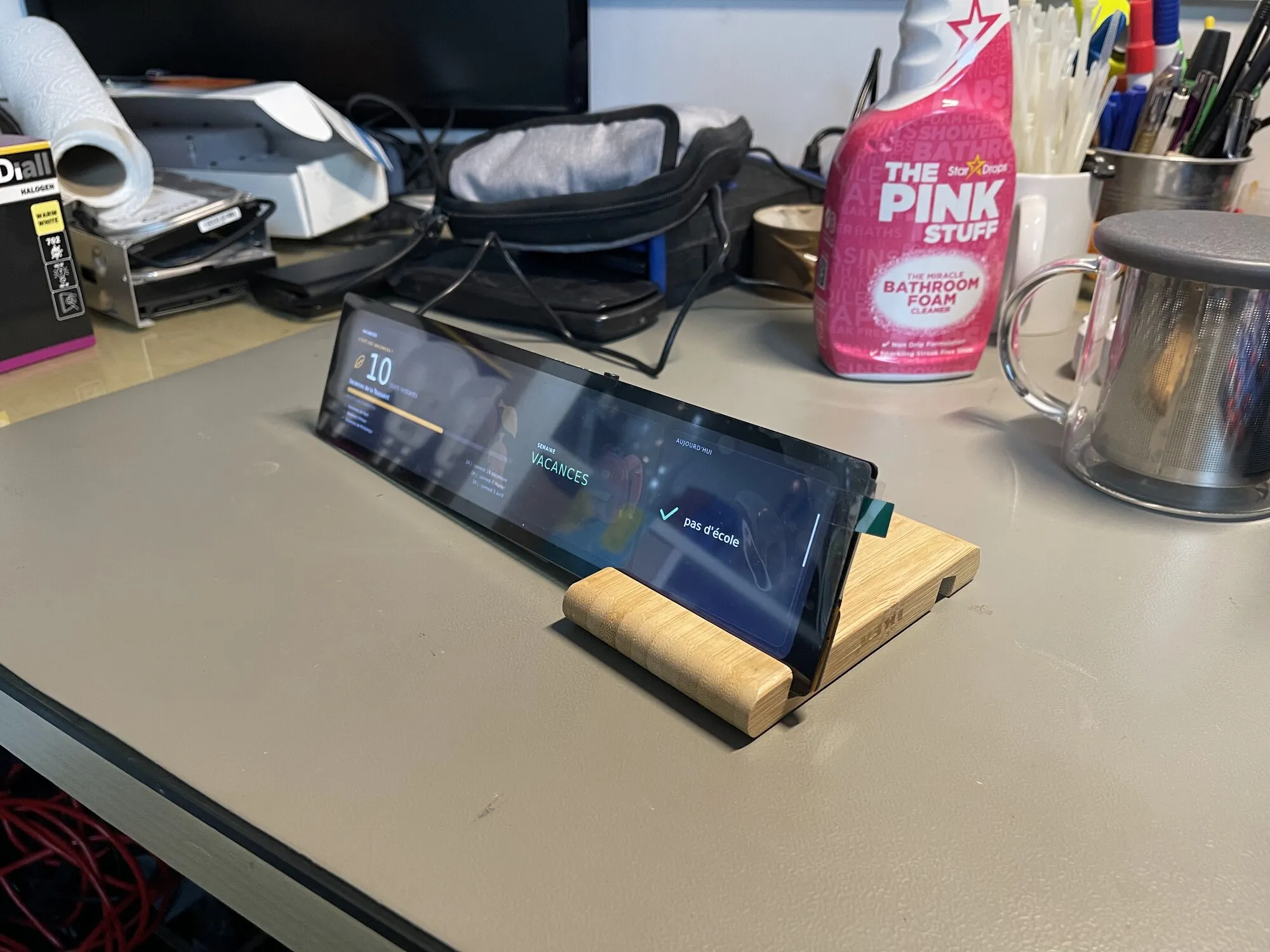 Le panneau posé sur un bureau, entre une bouilloire et un pot à crayons